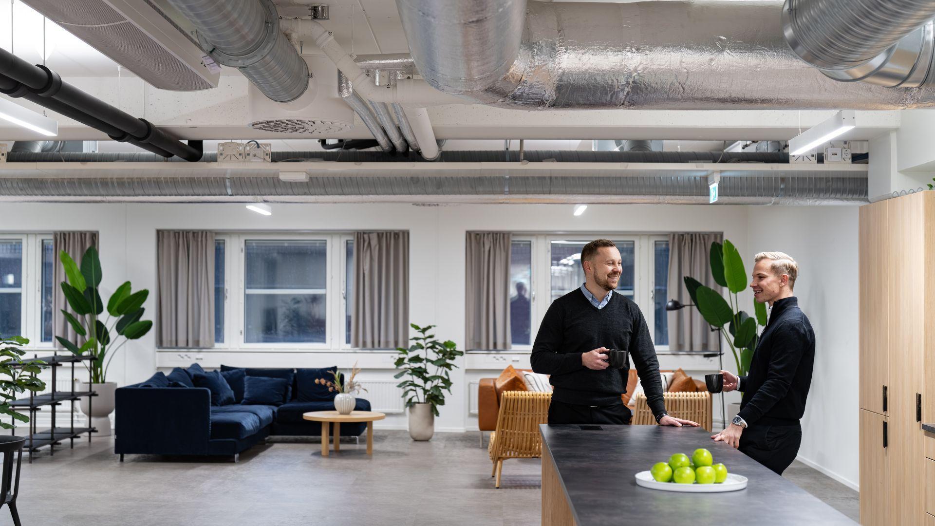 Two people talking in VillageWorks Ruoholahti common areas.