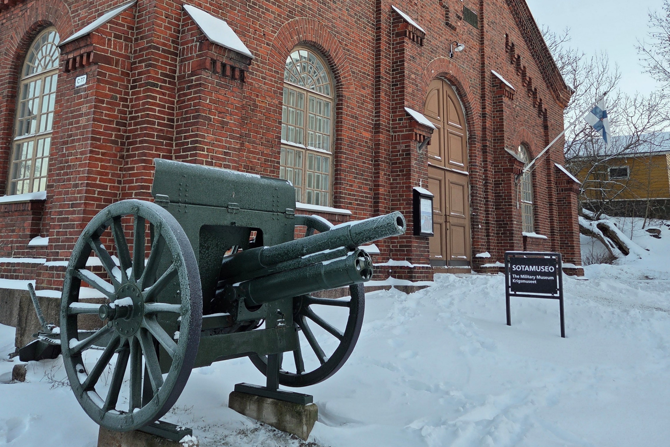 Kuvassa näkyy luminen museorakennus, jonka edessä on vanha tykki