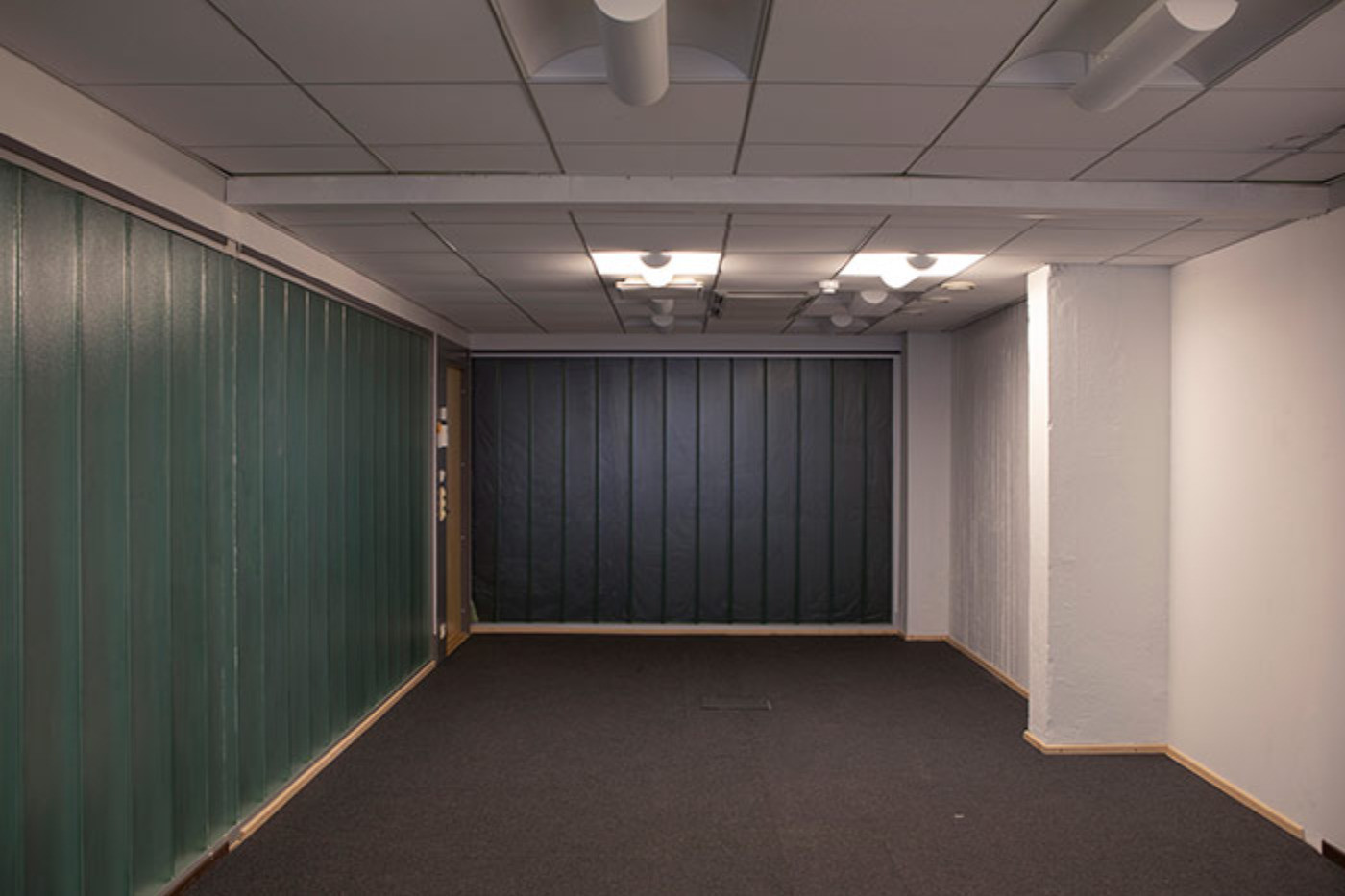 Kuvassa tyhjä lasiseinäinen neuvotteluhuone.