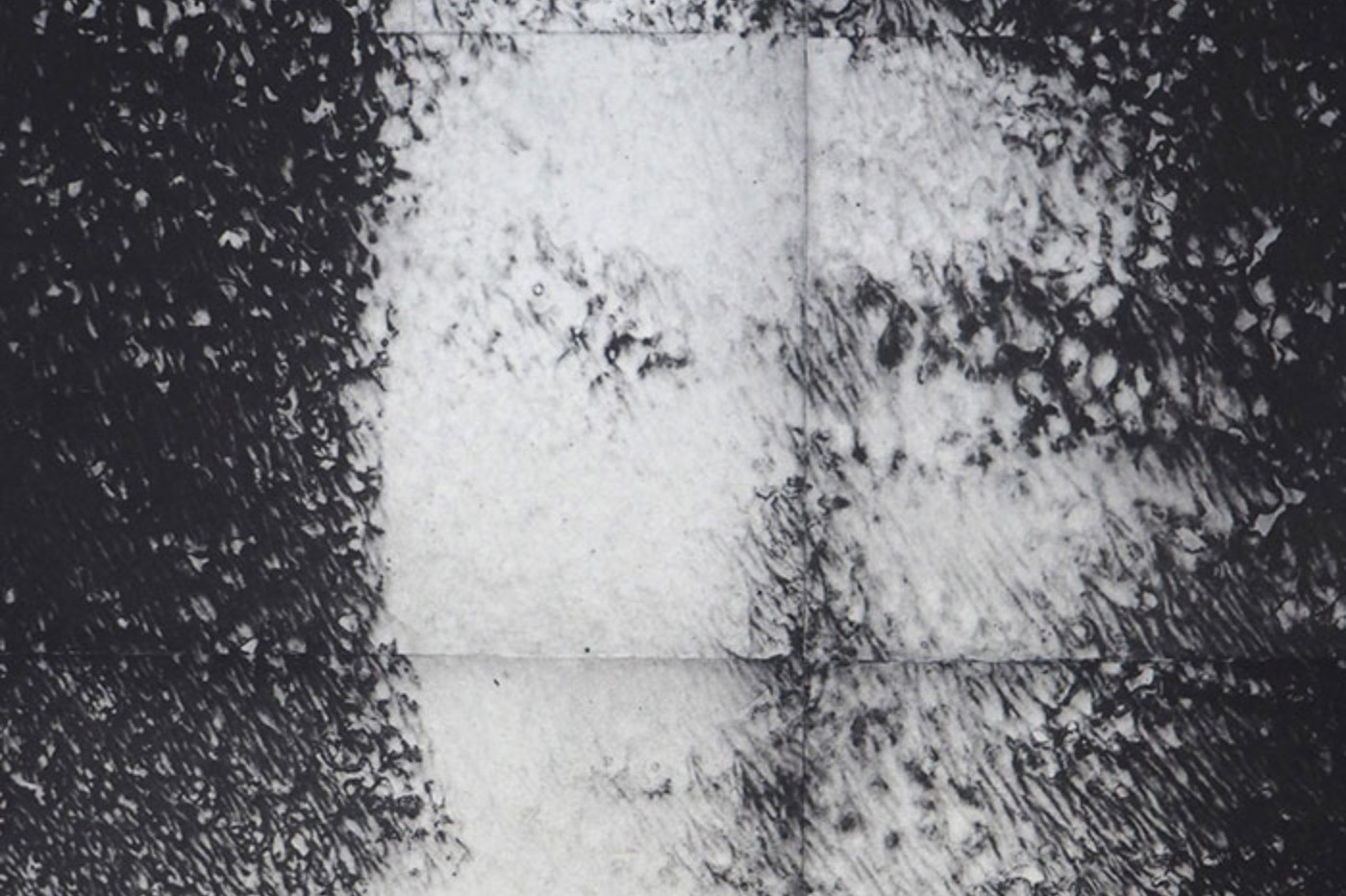 Mustavalkoineen kuva. Utuisesti vääristynyt kuva ihmiskasvoista.