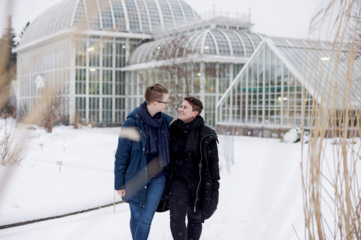 Couple walking in snowy landscape.