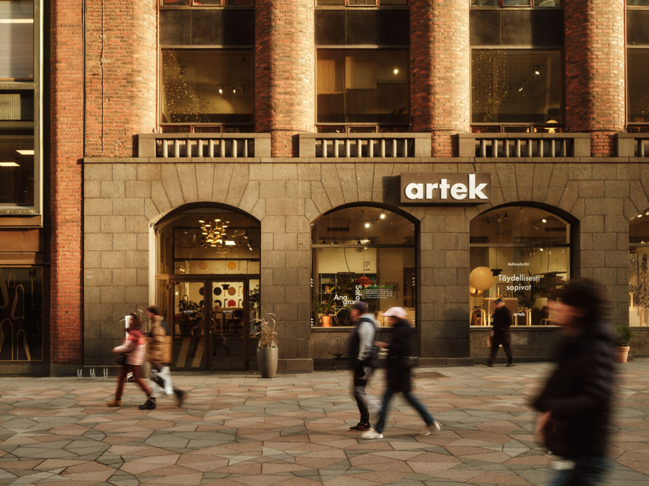 Artek-myymälän julkisivu, jonka edessä ihmiset kulkevat kivettyä jalkakäytävää pitkin