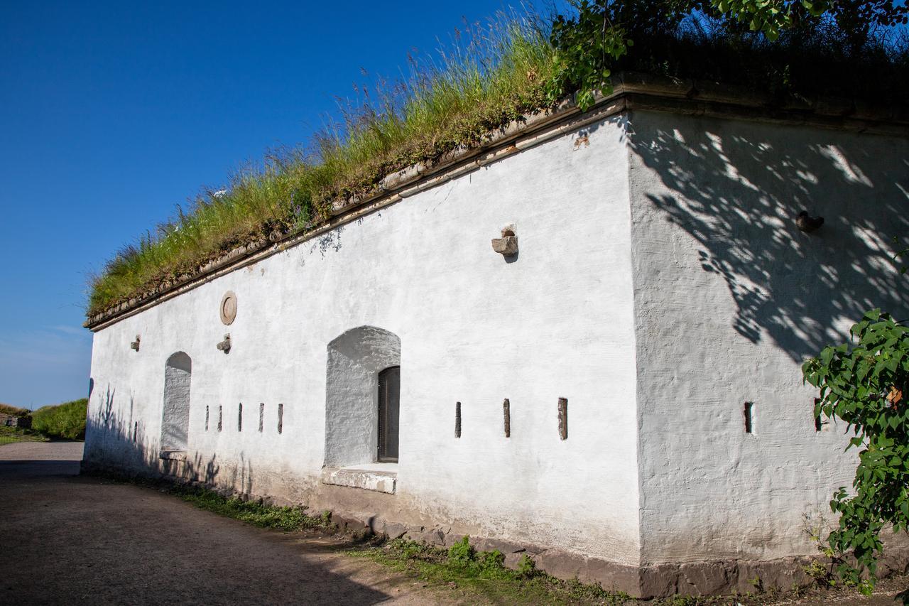 Ravintola Walhallan ravintolasali ulkoapäin kuvattuna. Valkoiseksi kalkittu linnoitusrakenne, jossa on turvekatto.