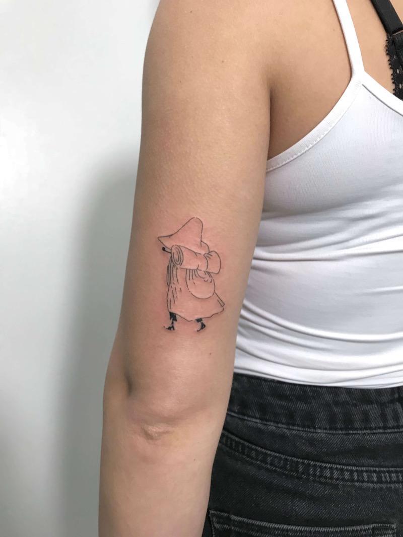 Snufkin fine line tattoo on upper arm - a black ink Moomin character piece by Irka Tattoo, Punavuori, Helsinki.
