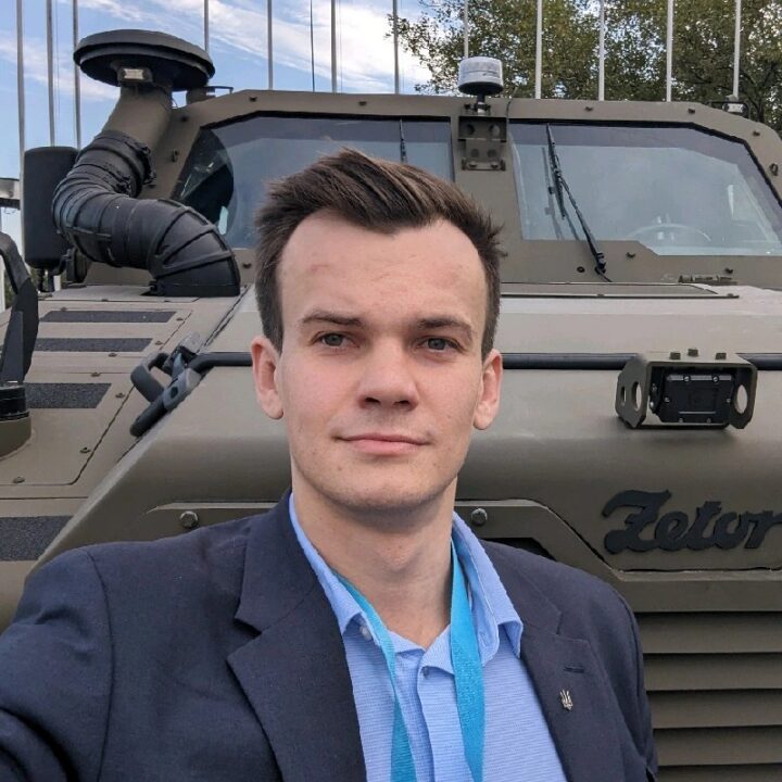 Man in suit standing in front of Zetor armored vehicle