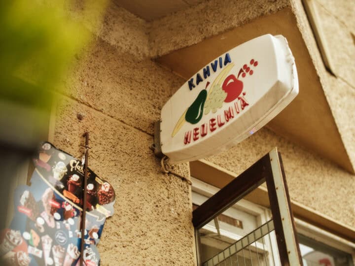 White Kahvia Hedelmia sign with fruit illustrations on a textured wall.