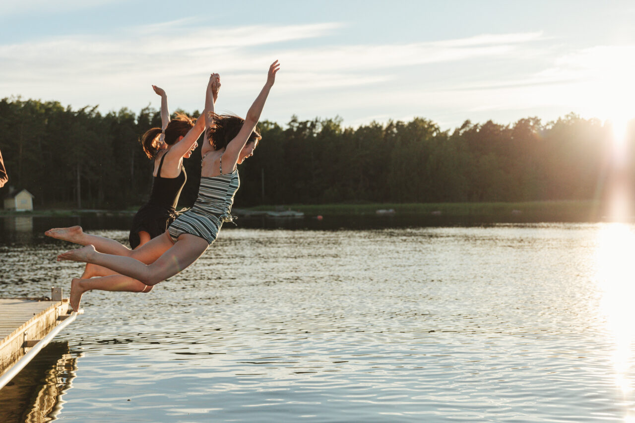 Girls jumping into a lake