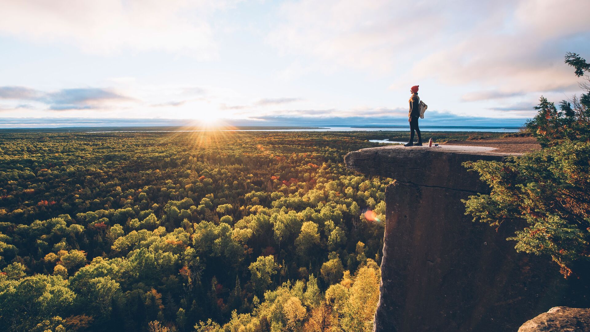 Person standing on cliff at sunset in Manitoulin Island, Canada