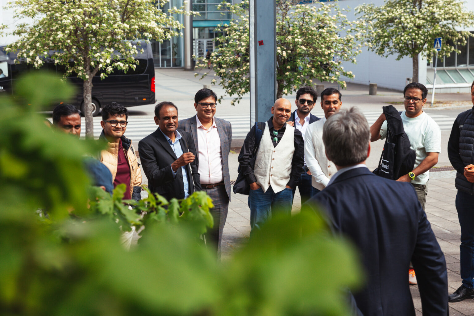 Group of men in formal attire gathered outdoors, possibly for a business meeting or event.