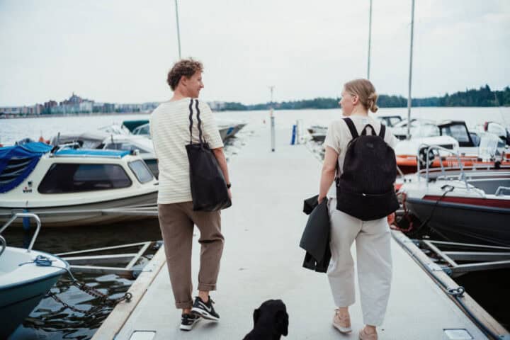 Couple walking dog on marina dock with boats